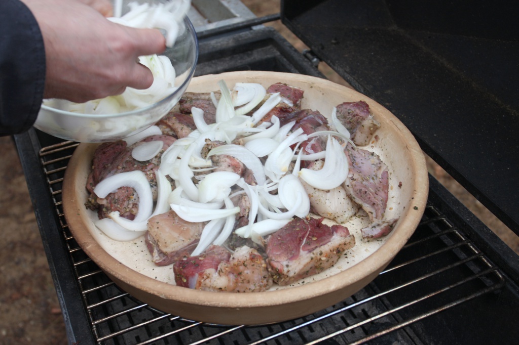 Приготовление баранина с овощами, приготовленные в керамической сковороде на гриле